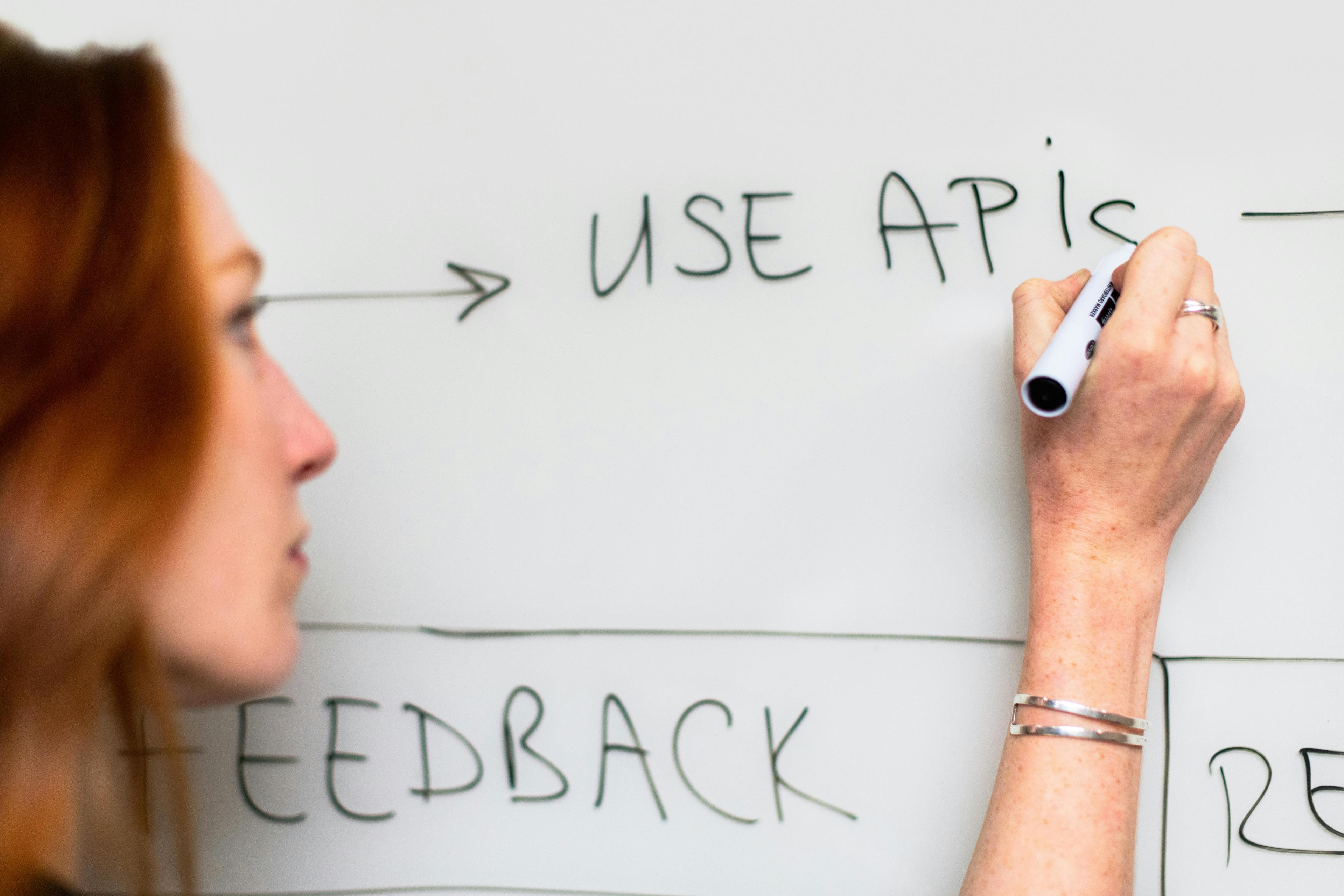 Woman writes on white board. 